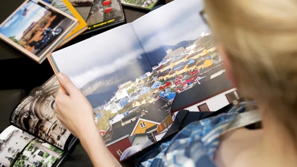 Frau mit Fotobuch in den H&auml;nden - &copy; Foto: Mascha Brichta/dpa-tmn