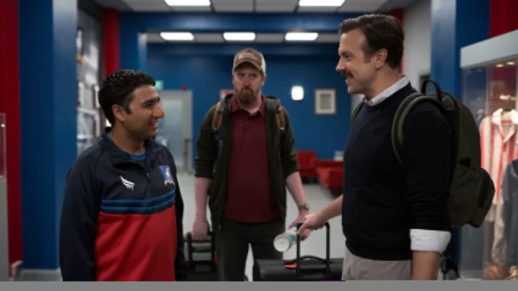 Tag eins im neuen Klub: Der introveriterte Mannschaftsbetreuer Nathan (links) f&uuml;hrt Ted Lasso (rechts) und seinen Kumpel, Co-Trainer "Coach Berd", zum B&uuml;ro ihrer neuen Chefin. - &copy; Apple TV+