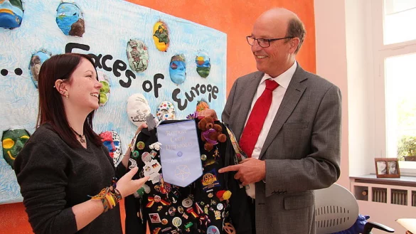 Der Blazer der Erinnerungen: Lisa Gurb präsentiert dem Detmolder Bürgermeister Rainer Heller die Pins und anderen Anstecker an ihrem Jackett des Rotary-Jugendaustausches. - © Foto: Engelhardt