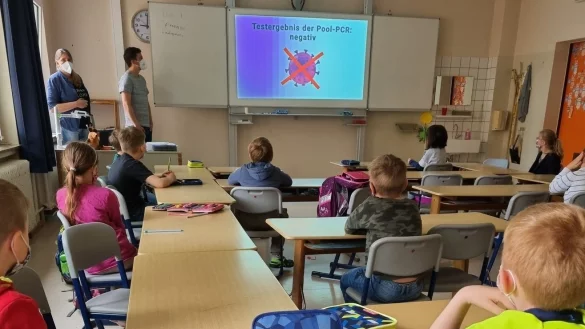 Die Schulleiterin der Grundschule West in Lemgo, Anke Heitmeier und Klassenlehrer Malte Frischen zeigen der Klasse 2b ein Video, das erkl&auml;ren soll, wie der Lolli-Test funktioniert. - &copy; Yannick Sonntag