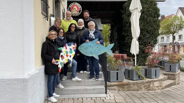 Maike Trompeter (von links), Angela Schirmag, Birgit Wiegrebe, Nicole Reineke, Bj&ouml;rn Strohmeier, Manuela Blome, Johann Falk und Steffi Gr&ouml;nke haben zur Einstimmung bunte Holzfische in der Stadt aufgeh&auml;ngt, die von Sch&uuml;lerinnen und Sch&uuml;lern des Gymnasiums Barntrup hergestellt wurden. - &copy; Marketingverein