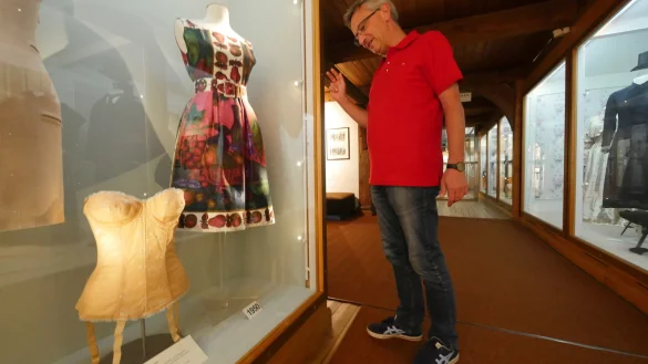 Mario Rakua vom Lippischen Landesmuseum schaut sich ein Kleid aus den 50er Jahren an. Links daneben ist ein Mieder aus den 60er Jahren zu sehen. Dieses Kleidungsst&uuml;ck sorgte auch schon in den 50er Jahren f&uuml;r die gew&uuml;nschte Wespentaille und dr&uuml;ckt gleichzeitig die Brust nach oben. - &copy; Jost Wolf