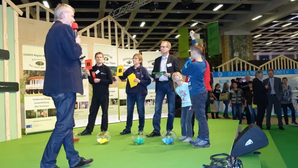Ein Quiz als Werbung f&uuml;r D&ouml;rentrup: Dr. Rudolf Diekmeier (links), Vorsitzender des Vereins "Tier im Dorf", stellt auf der B&uuml;hne bei der Gr&uuml;nen Woche in Berlin die Fragen. Mehrere Teilnehmer haben sich f&uuml;r Antwort B entschieden. - &copy; Privat