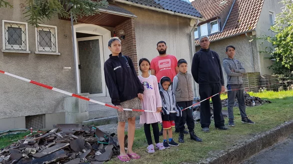 Nichts mehr zu retten: Die beiden Familien stehen vor den Tr&uuml;mmern des Brandhauses. - &copy; Marianne Schwarzer