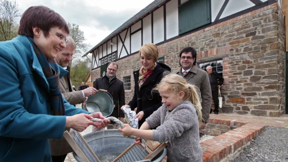 Gefion Apel, Leiterin des Museumsschläfer-Projekts, wringt mit Matilda ein Tuch aus, während Museumsleiter Prof. Dr. Jan Carstensen frisches Wasser in den Bottich nachgießt. Dr. Hubertus Michels, Anna Stein und Michael Pavlicic (von links) schauen zu. - © Bernhard Preuß