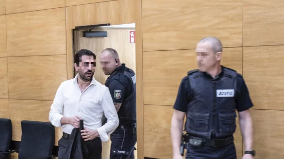 Der im Fall Nimani Angeklagte Hüseyin A. (l.) wird von Justizbeamten zur Anklagebank im Bielefelder Landgericht geführt. - © Jörg Dieckmann