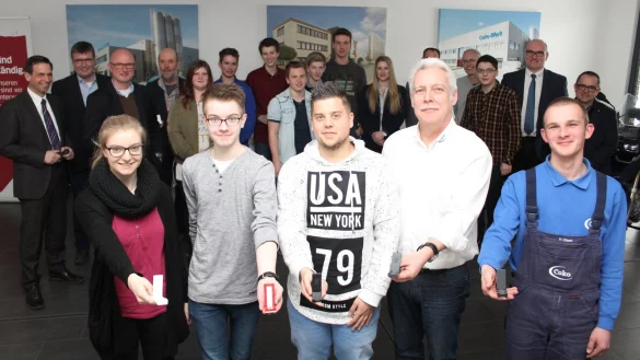 Sind stolz auf das Ergebnis: (vorne, von links) Sch&uuml;lerin Jana Scholz, Rene Knorr, Auszubildender Christopher Hoppe, Holger Bollh&ouml;fer und Werkzeugmechaniker Alexander Zibart pr&auml;sentieren die fertigen Smartphone-St&auml;nder. - &copy; Ruben Honermeyer