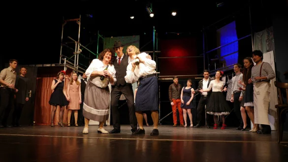 Trinkfreudige Inszenierung: Mutter &bdquo;Cate" (John Pickering), Cavaliere Astolfi (Niklas Clarin) und &bdquo;Pasqua" (Xiao Zhang) feiern mit den Choristen. - &copy; Thomas Kr&uuml;gler