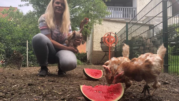 Petra St&uuml;ker mit H&uuml;hnern in ihrem Garten. - &copy; Sven Kienscherf