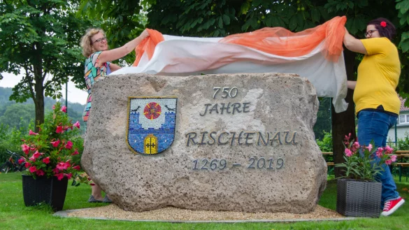 K&uuml;nstlerin Anja Meier-Schirra (links) und Maren Becker von der Dorfgemeinschaft Rischenau enth&uuml;llen den Jubil&auml;umsstein. - &copy; Raphael Bartling