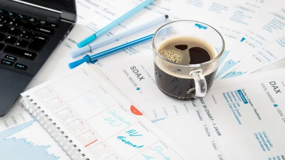 Eine Kaffeetasse steht auf Aktien-Unterlagen - &copy; Foto: Christin Klose/dpa-tmn