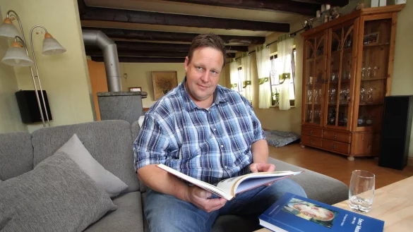 Ingo M&uuml;hlenmeier sitzt in seinem Wohnzimmer und bl&auml;ttert in der Dorfchronik von G&uuml;nter Meier. Das Engagement im Dorf und in der Kalletaler Kommunalpolitik ist seit Jahrzehnten sein Ding.&nbsp; - &copy; Jens Rademacher