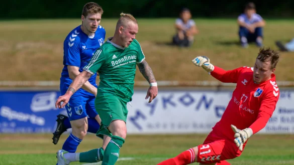 Ahmsens Sören Seifert (Mitte) stürmt auf das gegnerische Tor zu. Der Salzufler Torhüter Marcel Frormann und Marcel Funke haben das Glück des Tüchtigen. Der Ball bleibt am Torhüter hängen. - © Egon Penner