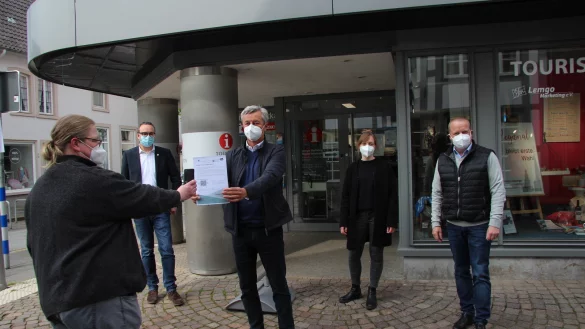 Anja Limberg scannt den QR-Code von &bdquo;Darfichrein", den ihr Wolfgang J&auml;ger (Lemgo Marketing) entgegenh&auml;lt. Mit dabei sind auch (von links) B&uuml;rgermeister Markus Baier, Projektleiterin und Ansprechpartnerin Nicole B&auml;umer sowie Kalletals B&uuml;rgermeister Mario Hecker. - &copy; Katrin Kantelberg