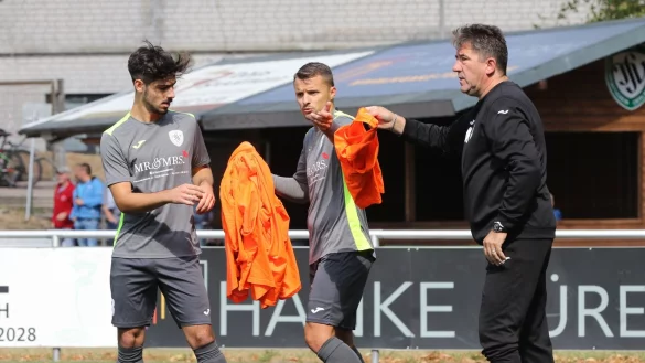 Der Trainer gibt das Leibchen weiter: Oerlinghausens Coach Miron Tadic versorgt Mikail Bas (links) und Kapitän Dawid Stroisz. - © Oliver König