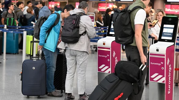 Reisende schieben in der Abflughalle des D&uuml;sseldorfer Flughafens zur Halbzeit der Sommerferien in Deutschland ihre Koffer zur Gep&auml;ckaufgabe. - &copy; Roberto Pfeil/dpa