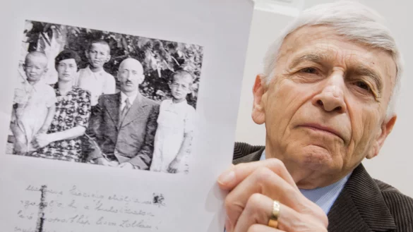 Der Auschwitz-Überlebende Max Eisen zeigt am 23.04.2015 im Gerichtssaal in Lüneburg (Niedersachsen) ein Foto aus dem Jahr 1940, welches ihn als Kind (3.v.l.) mit seinen Eltern und seinen Brüdern zeigt. 70 Jahre nach Ende der Nazi-Diktatur steht der frühere SS-Mann Oskar Gröning in Lüneburg vor Gericht. Die Anklage wirft ihm Beihilfe zum Mord im Vernichtungslager Auschwitz vor - in mindestens 300.000 Fällen. - © dpa