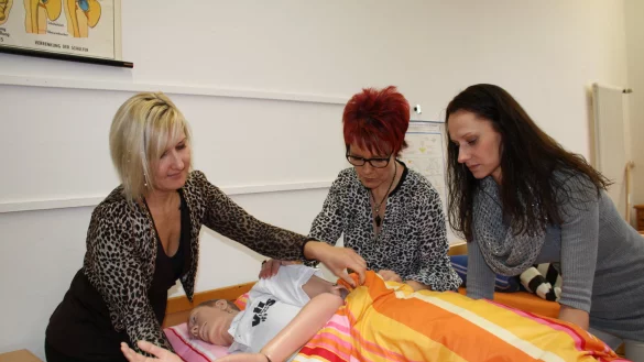 Üben am Dummy. In der Praxis sind die Pflegeschülerinnen Natalie Müller, Melanie Buchholz und Nadine Förster (v. links) später mit dem Patienten allein. - © Freya Köhring