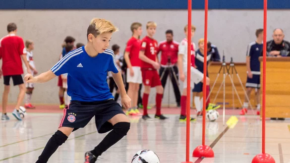 Während der aus Schlangen kommende Joshua Kubi den Ball um die Stangen tanzen lässt, konzentrieren sich seine Mitspieler auf die nächste Aufgabe. Im Hintergrund laufen die Kameras mit. - © Egon Penner