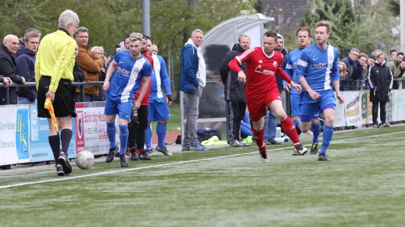 Vor den Augen des Schiedsrichter-Assistenten und der vielen Zuschauer: Augustdorfs Alexander Eck (rotes Trikot) findet die Lücke zwischen den Jerxer Gegenspielern. - © Oliver König