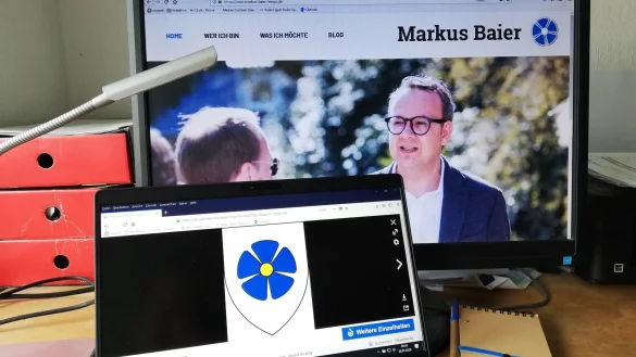 B&uuml;rgermeisterkandidat Markus Baier verwendet auf seiner Homepage (hinten) ein Logo, dass der Blume des Lemgoer Stadtwappens &auml;hnelt. - &copy; Carolin Brokmann-F&ouml;rster