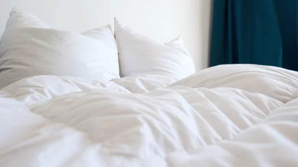 Bettdecken und Kissen liegen auf einem Bett - &copy; Foto: Andrea Warnecke/dpa-tmn