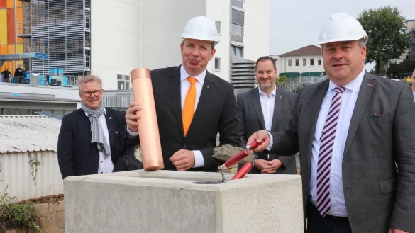 Thomas Lammering, 1. Technische Beigeordnete des Bürgermeisters, Klinikum-Geschäftsführer Dr. Johannes Hütte, Aufsichtsratmitglied Carsten Möller und Landrat Dr. Axel Lehmann (von links) zementieren die „Bombe" mit den Unterschriften aller Teilnehmer ein. - © Janet König