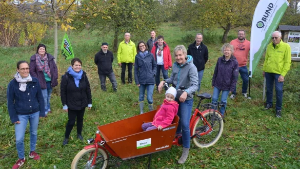 Harald Kohls (Bild rechts) und seine BUND-Mitstreiter k&uuml;mmern sich unter anderem um die Pflege der Streuobstwiesen im Ortsteil Werl. Die kleine Layana Lutterbeck ist vom Sala-Lastenrad ganz begeistert. - &copy; Georg K&auml;lble