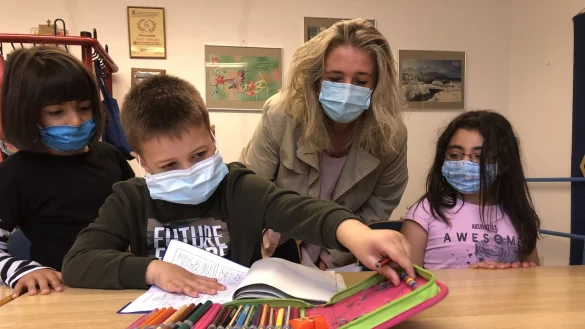 Shirin, Aiden und Nojin (von links) lernen unter Aufsicht von Katharina Idecke in der Gelben Schule. Zum Hygienekonzept geh&ouml;rt, dass alle eine Maske tragen. Zudem werden Anwesenheitslisten gef&uuml;hrt. - &copy; Sven Kienscherf