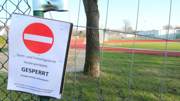 Der Heidesportplatz ist wegen der Corona-Beschr&auml;nkungen geschlossen und mit Bauzaun-Elementen abgesperrt. Nur die Real- und Grundschule d&uuml;rfen ihn f&uuml;r den Schulsport nutzen. Ein gro&szlig;es Schlupfloch im im noch verbliebenen St&uuml;ck Maschendrahtzaun in der Westecke erm&ouml;glicht aber ungehinderten Zugang. - &copy; Dieter Asbrock