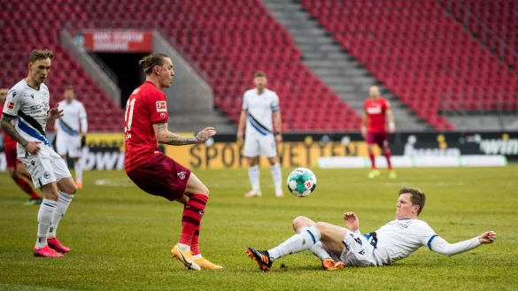Arminias Joakim Nilsson k&auml;mpft im Liegen mit dem K&ouml;lner Marius Wolf um den Ball. - &copy; BEAUTIFUL SPORTS/WUNDERL/POOL