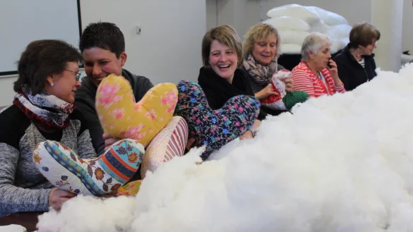 Fleißig: Viel Spaß haben die Helfer beim Ausstopfen der Herzkissen. - © Anna Muer