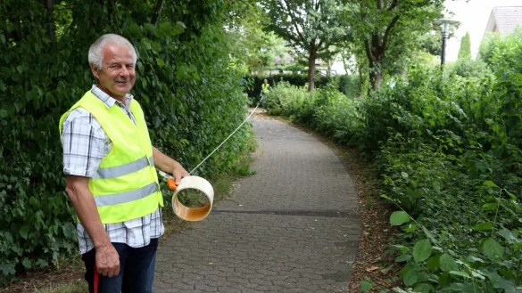 Abwasseringenieur Robert Blank h&auml;lt auf einem Fu&szlig;weg am Adlerweg ein Ma&szlig;band, an dessen Ende hinten vor der Hecke Ingenieur Matthias Kindsgrab steht. So lang wird die Maschine sein, mit deren Hilfe ein sogenannter Inlinerschlauch in den Kanal gezogen wird, der damit abgedichtet und stabilisiert wird. - &copy; Thomas Dohna