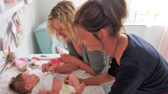 Nachsorge durch die Hebamme: Bei Caja Beermann und der stolzen Mutter Denise läuft nach der Geburt alles vorbildlich. Jutta Twete (vorne) wirft beim Besuch einen genauen Blick auf den Säugling, der im Bild gerade sechs Wochen alt ist. - © Tanja Andersen