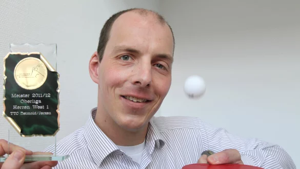 Kann selber auch ordentlich Tischtennis spielen: Sebastian Sch&auml;fer l&auml;sst den Ball auf dem Schl&auml;ger springen, links der Pokal f&uuml;r die Oberliga-Meisterschaft 2012. Er war der gr&ouml;&szlig;te Erfolg der Vereinsgeschichte. - &copy; Vera Gerstendorf-Welle