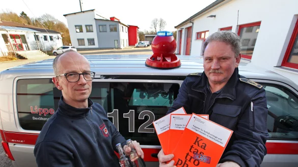 Vorsorge f&uuml;r den Notfall f&auml;ngt mit ein paar Flaschen Wasser auf Vorrat an und das d&uuml;rfen ruhig ein paar mehr sein, als Hans-Dieter L&ouml;dige hier in der Hand h&auml;lt. Was genau, steht unter anderem in der Brosch&uuml;re, die Kreisbrandmeister Wolfgang Kornegger zeigt. F&uuml;r das Foto haben beide zudem eine mobile Sirene/Lautsperecheranlage aufs Autodach montiert. - &copy; Bernhard Preuss