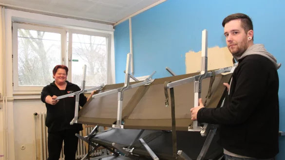 Alles muss raus: Sandra Sommer und Yannic Winter packen die Feldbetten in der ehemaligen Anne-Frank-Schule zusammen. Schon wenige Stunden nachdem die letzte Familie die Notunterkunft verlassen hat, stehen die meisten Zimmer leer. Doch nach dem Umbau soll bald wieder Leben einziehen. - &copy; Marlen Grote