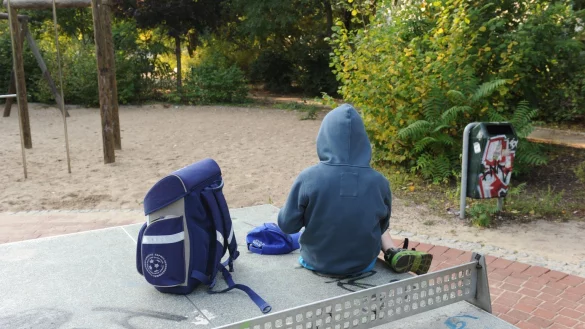 Kind mit Schulranzen auf Spielplatz - &copy; Foto: Jens Kalaene
