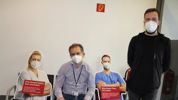 Pappaufsteller, f&uuml;r die Krankenhaus-Mitarbeiter vor der Kamera gestanden haben, dienen im Klinikum als Abstandshalter. Chefarzt Daniel Fischer (sitzend) und Martin Wall von der Klinik-Einsatzleitung werben daf&uuml;r, die Kontakte einzuschr&auml;nken.&nbsp; - &copy; Astrid Sewing