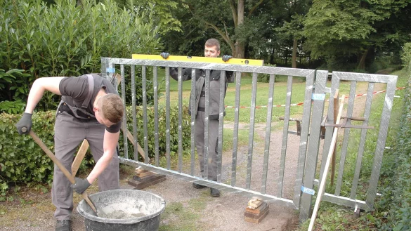 Kein Durchgang mehr: Vincent Giesen (links) und Lars Oetting von der Schlosserei Beerensmeier stellen gerade ein fehlendes Tor auf. - © Manfred Brinkmeier
