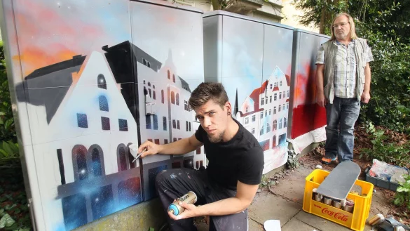 Wie gemalt: K&uuml;nstler Dan Geffert gestaltet die grauen Stromk&auml;sten zu Kunstwerken um. Erhard Krull begutachtet es. - &copy; Frank-Michael Kiel-Steinkamp