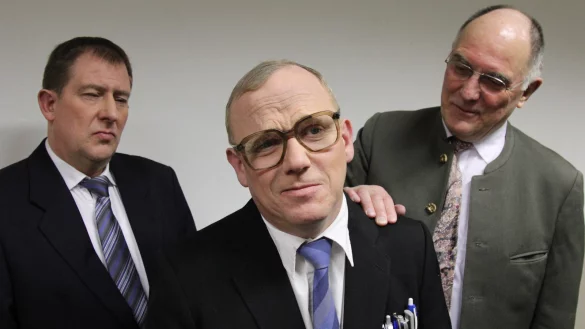 Amtsschreiber Willi Winzig (Axel Wieneke, Mitte) will die K&uuml;rzung seiner Pension verhindern. Auf dem Foto sind auch sein Sektionschef Doleschall (Reinald Rohlfs-Blume, links) und Finanzminister Kuhlender (Lutz Lehmann) zu sehen. - &copy; Freilichtb&uuml;hne Bellenberg