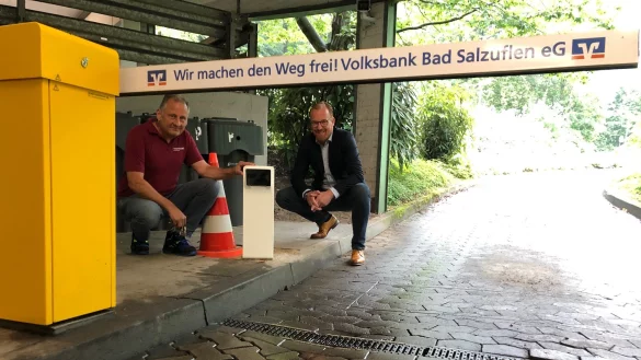 Ernst-August Menke und Volker Stammer (von links) von den Stadtwerken knien neben der Kamera, die k&uuml;nftig die Kennzeichen erfasst, damit sich die Schranke ohne weiteres Zutun hebt. - &copy; Sven Kienscherf