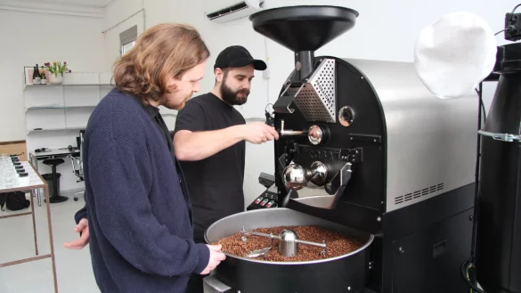 Christian Langemann (links) und Nathan Neifer betreiben eine eigene Kaffeer&ouml;sterei. Hier stehen sie am Kernst&uuml;ck, der R&ouml;stmaschine. - &copy; Archivfoto: Jana Beckmann