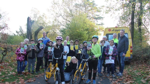 Die neue Ausbildungsbrosch&uuml;re unterst&uuml;tzt die Viertkl&auml;ssler an der Kusselbergschule bei der Vorbereitung auf das Radfahren auf den Stra&szlig;en. Bei der &Uuml;bergabe sind Klassenlehrer Swen van der Heijden (hinten, von links), Tanja Menze, Karsten Seefeld, Heinz-Josef Fischer von der Verkehrsunfallpr&auml;vention der Polizei und Jens Klusmeier von der Lippischen Landesbrandversicherung dabei. - &copy; Cordula Gr&ouml;ne