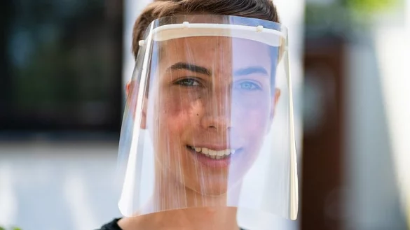 Schüler Bastian Steinlein trägt ein von ihm mittels 3D-Drucker angefertigtes Faceshield. - © picture alliance