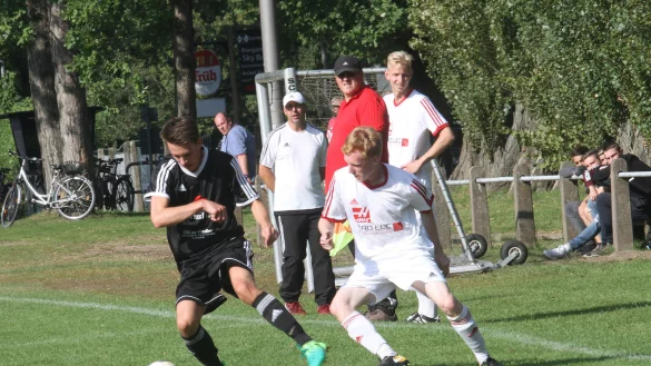 Lipperreihes Trainer Carsten Schulze (im Hintergrund mit roten Schuhen) und sein Betreuer Tim Meister (rotes Trikot) schauen dem Zweikampf zwischen Aspes Jan-Hendrik Lange (links) und Ruben Leon Steinkamp zu. - &copy; Dietmar Welle