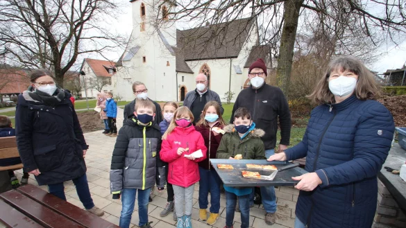 Pizza vom neuen Freiluft-Backofen mit (hinten, von links) Lehrerin Christiane H&uuml;ttemeier, Schulleiterin Kirsten Pielsticker, Hans-Peter Wegner vom Bauausschuss der evangelisch-reformierten Kirchengemeinde Hohenhausen sowie den beiden Gemeindep&auml;dagogen J&ouml;rg und Angelika B&ouml;nnemann sowie den Viertkl&auml;sslern (vorne, von links) Raul, Wiebke, Malia, Anna und Joel. - &copy; Jens Rademacher
