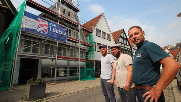 Geschichtstr&auml;chtiges Geb&auml;ude: Die Neu-Gastronomen (von links) Max und Michael Beckett sowie Malermeister Thorsten Gutsell stehen vor dem Fachwerkhaus an der Krummen Stra&szlig;e 44, das der Handwerker restauriert. - &copy; Patrick Bockwinkel