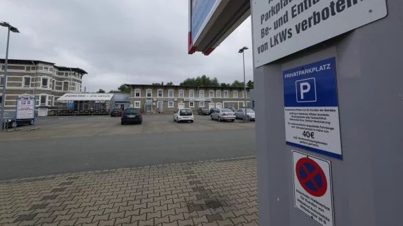W&auml;hrend auf den Schilder am Fu&szlig; einer Werbetafel keine zeitliche Beschr&auml;nkung f&uuml;r den Parkplatz an der alten Schlachterei angegeben ist, vermerkt der Aufsteller des Getr&auml;nkemarkts links im Hintergrund eine Parkzeit von maximal einer Stunde. - &copy; Jost Wolf